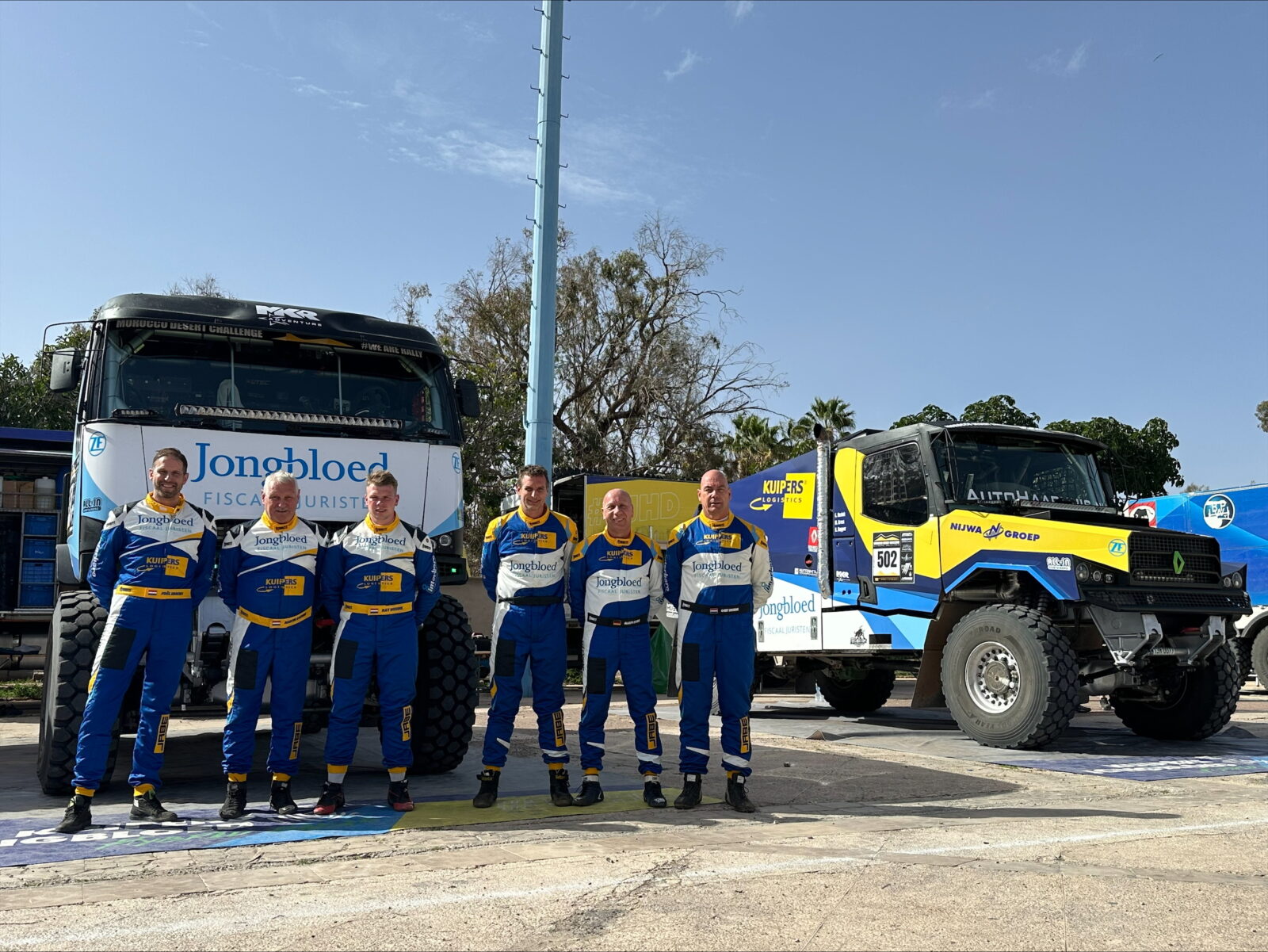 Het Kuipers-Jongbloed Hybrid Dakar Team staat voor de trucks op een rijtje